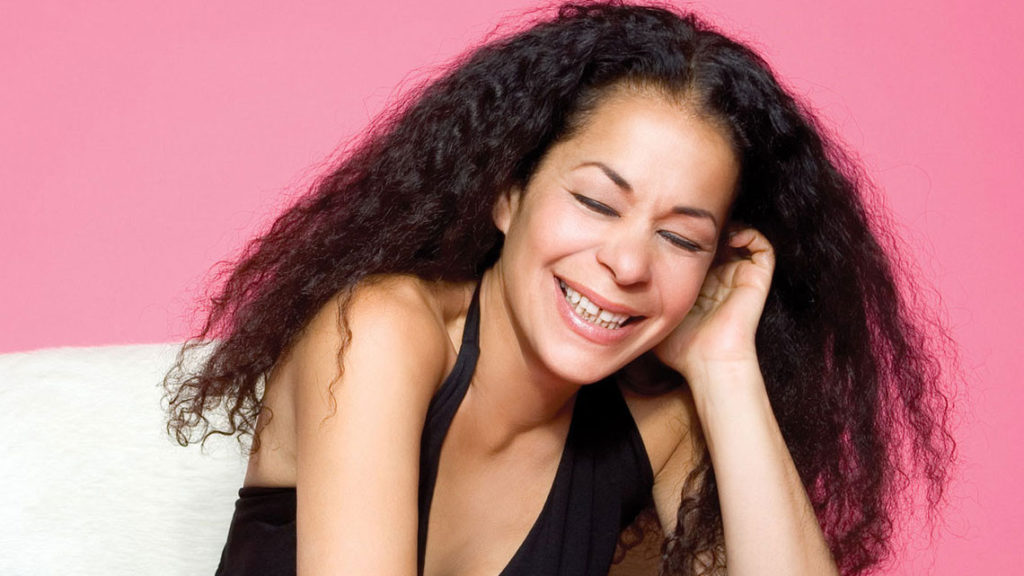 Portrait of Molly Johnson Smiling against a pink background