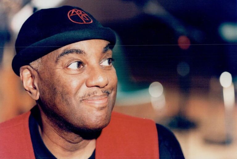 Headshot of Joe Sealy wearing a hat glancing to the side and smiling after recently winning Juno Award for "Africville Suite".