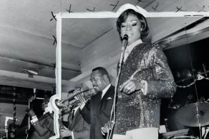 Jackie Shane singing into the microphone at a performance.
