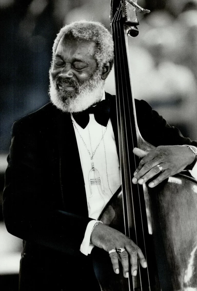 Black and white photo of Charlie Biddle performing with his double bass in a tuxedo, exuding his musical talents and passion.