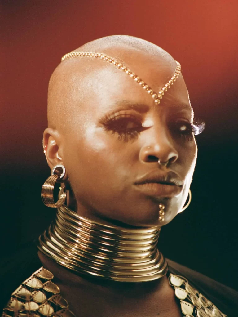 Close up image of SATE, wearing all gold, including jewelry and face gems