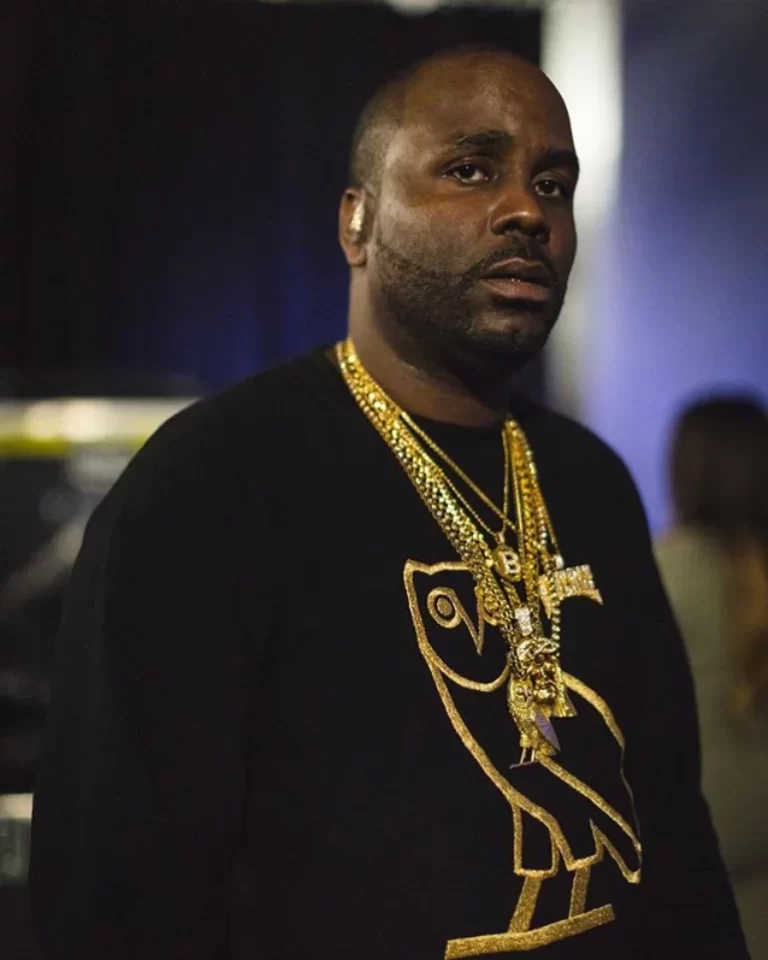 Baka Not Nice in a medium-shot photograph wearing several chains and a black sweater with October's Very Own (OVO) logo