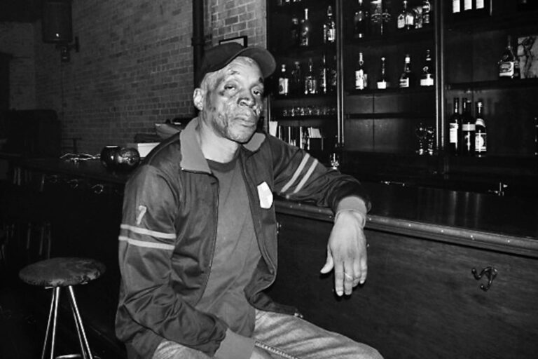 Black and white of Allen sitting at the bar