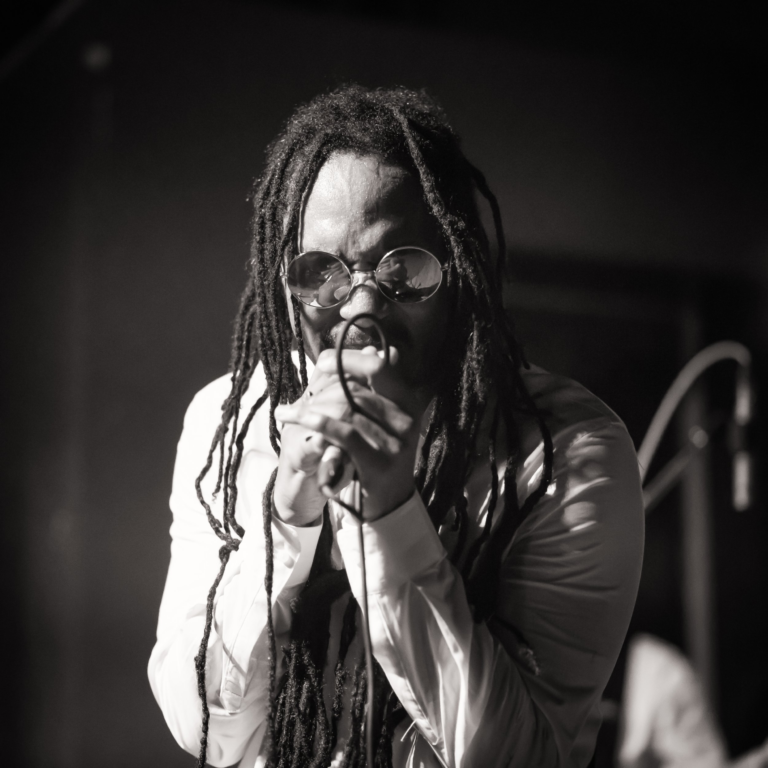 Black and white of Jah Beng singing into mic