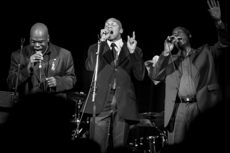 The Sojourners black and white image of them singing on stage