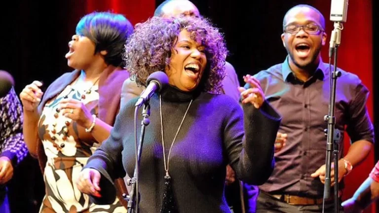 Medium shot of Sharon Riley & Faith Chorale performing and singing energetically on stage