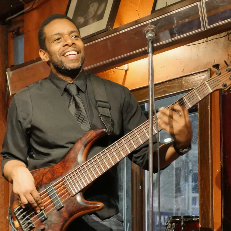 Rich Brown smiling on stage playing guitar