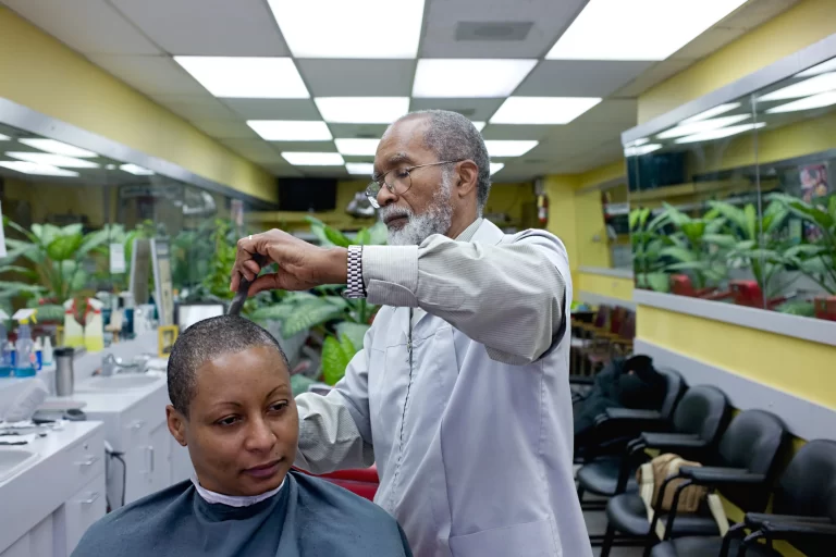 Jimmy Wisdom cutting hair in his barbershop