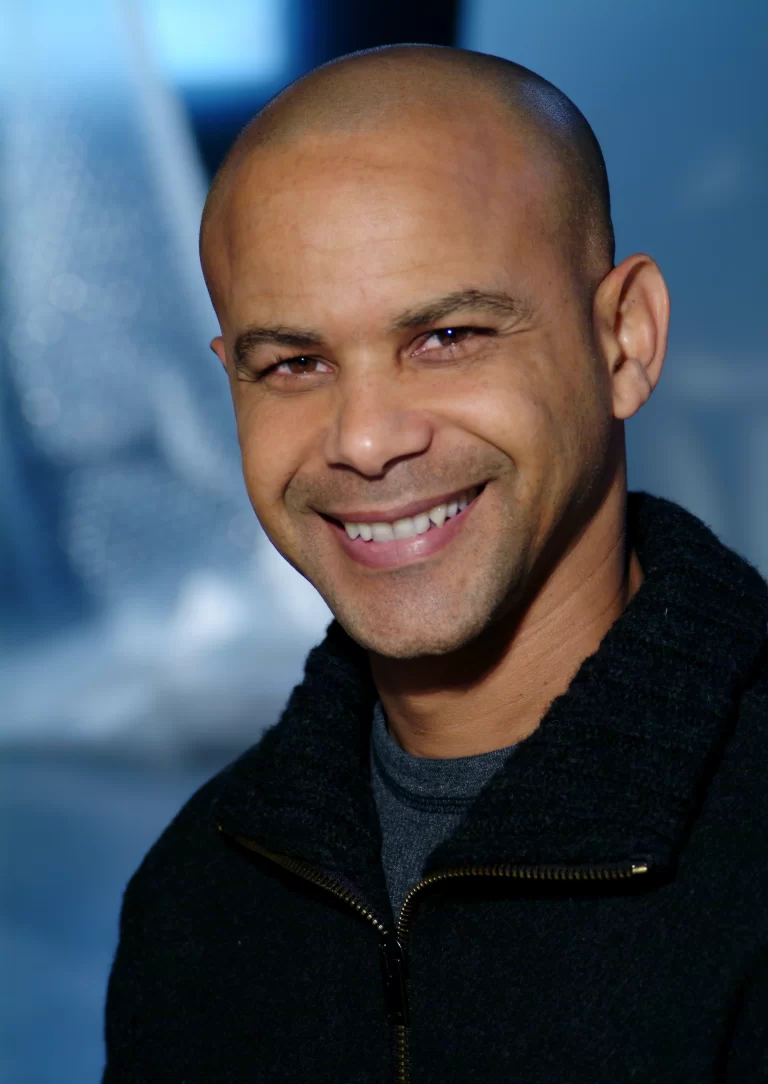 Close-up of Ivan Berry, smiling, in front of blue background