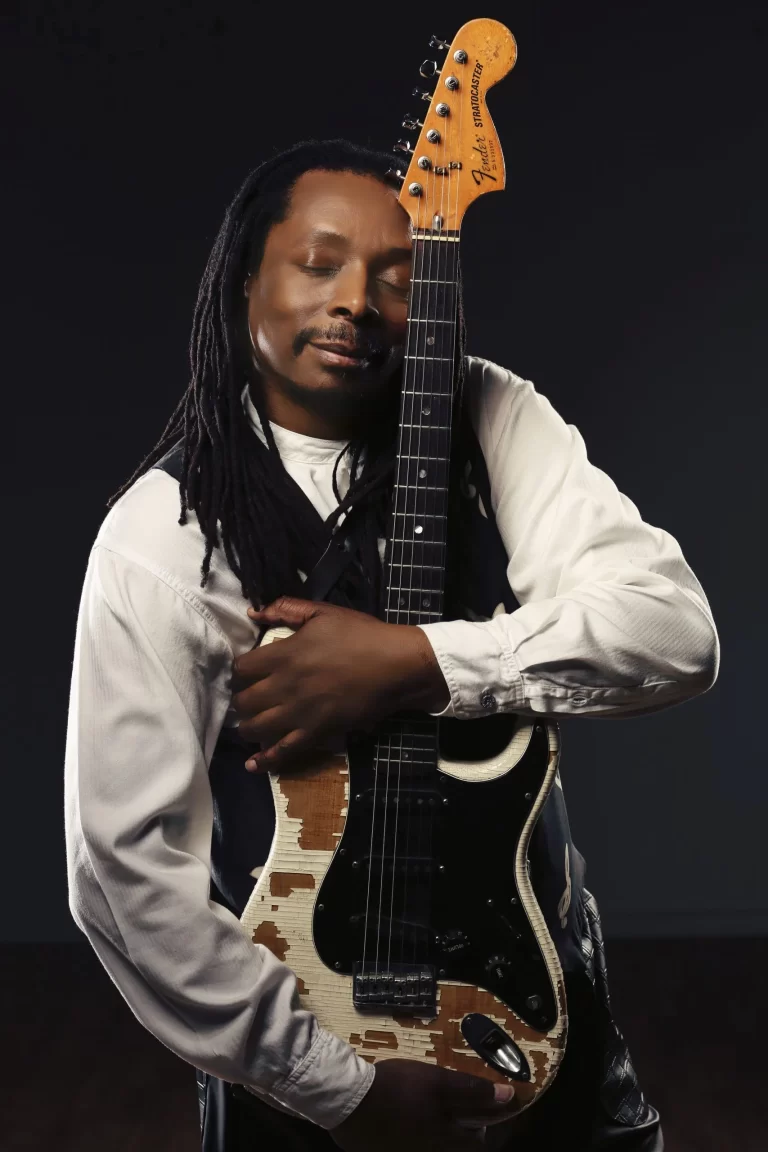 Image of Errol Starr hugging his guitar with his eyes closed