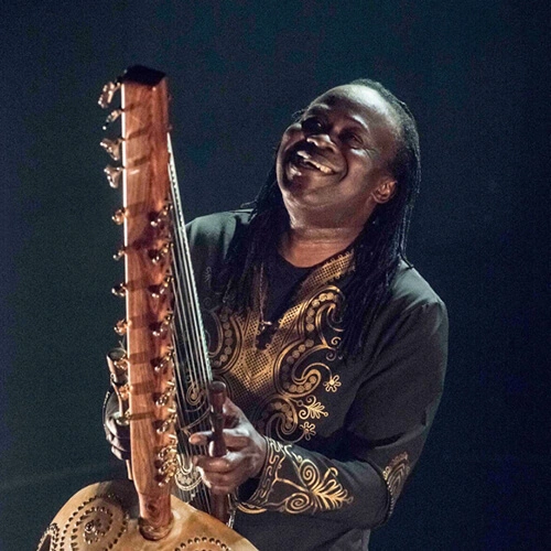 Zal Sissokho performing on stage, smiling looking up