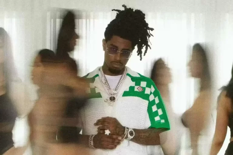 NorthSideBenji in white and green shirt, blurred surroundings